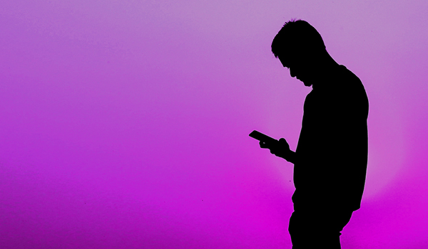 einsamer Mann schaut auf Smartphone